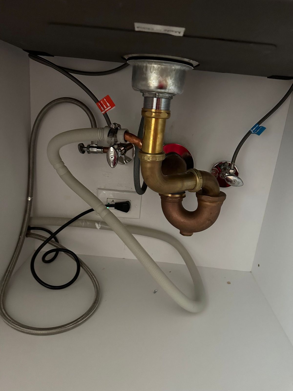 Brass P-trap and supply lines under a new sink, installed by I&I Plumbing